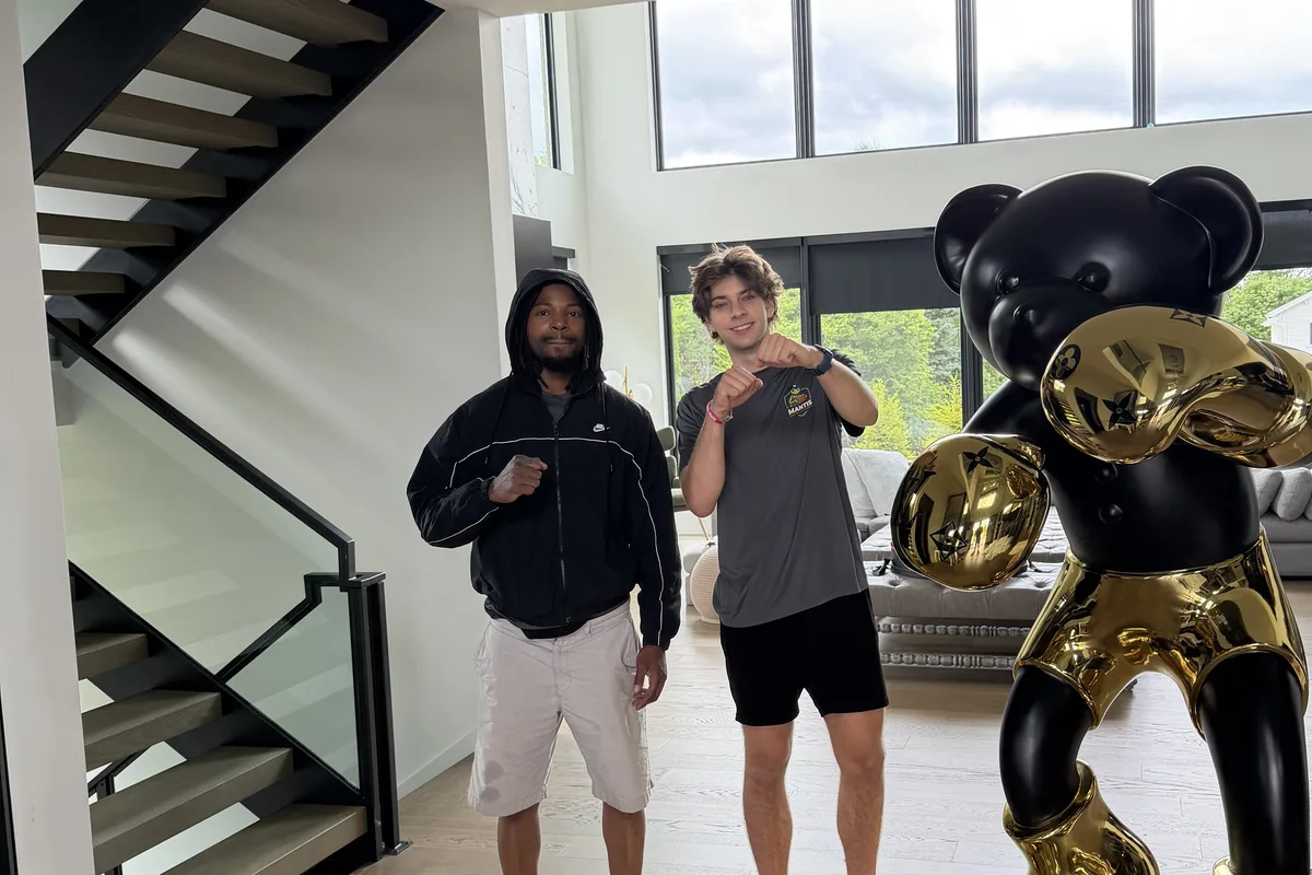 Two Mantis Moving crew members beside a black and gold bear sculpture in a client's home